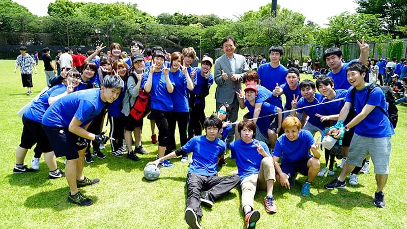 青いお揃いTシャツを着たミュージックカレッジ学生のみなさんと千葉理事長