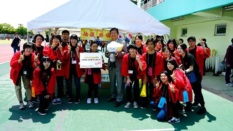 赤いお揃いの法被を着た体育祭実行委員のみなさんと千葉理事長