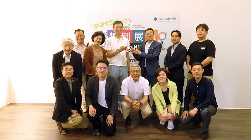 ぱっちぃのぬいぐるみを持ち参加者と記念撮影する千葉理事長