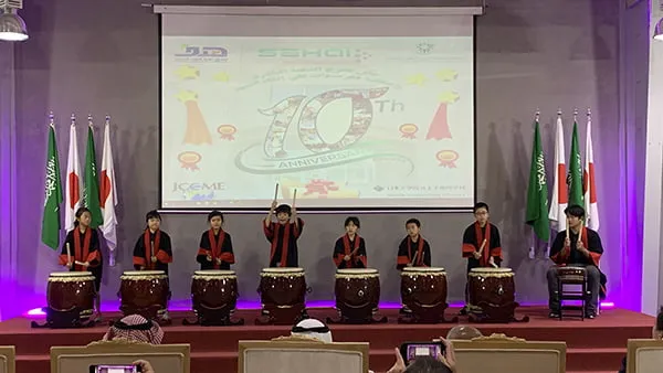 8人の生徒たちが壇上で和太鼓を披露する姿