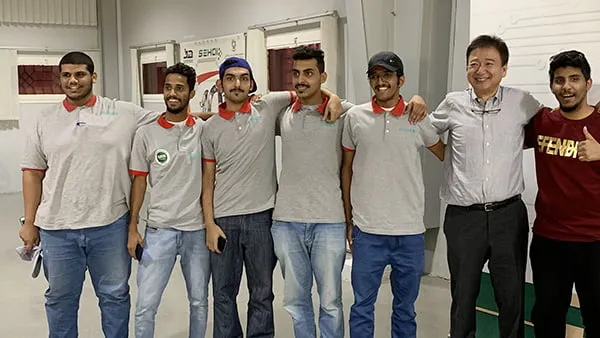 千葉理事長と6人の卒業生たちが肩を組んで並んでいる姿