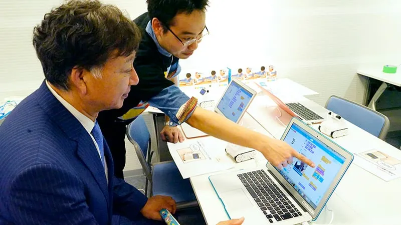 実際にプログラミングを体験する千葉理事長とスタッフ