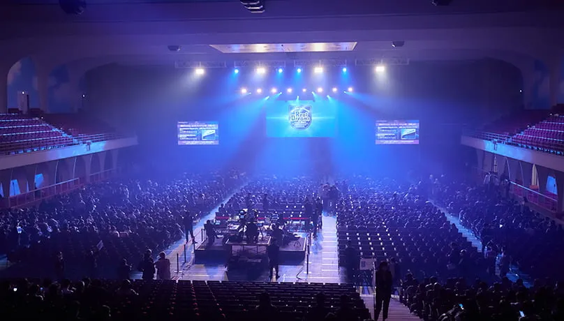 REAL DREAMS演目中の会場。薄暗い会場の中、ステージから客席全体にブルーのライトが照らされている風景。
