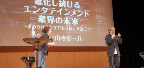 笑いながら壇上でトークする山寺さんと富永先生