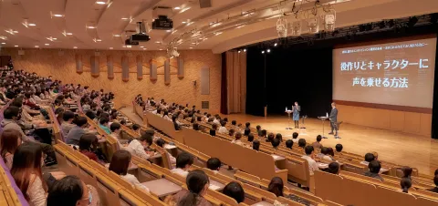 壇上の2人とそれを見つめる生徒たち