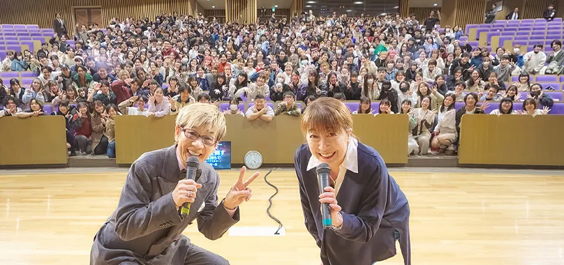 沢山の生徒たちをバックに記念撮影する山寺さんと富永先生