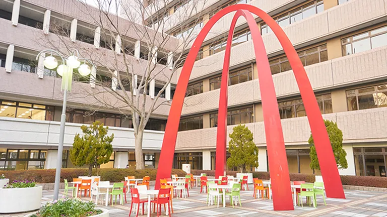 交差する赤い半円状のオブジェを見上げる形で設置されたテラス席