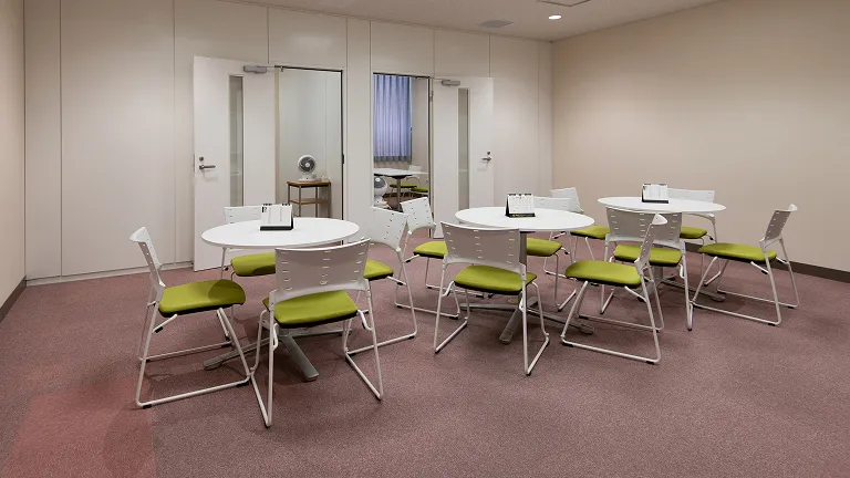 丸テーブルと4脚の椅子のセットが並んだ明るくすっきりした室内