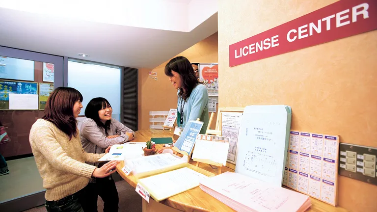 各種資料が置かれたカウンターで生徒と職員が談笑している様子