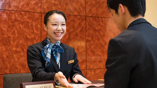 学生が実習先でフロントでの接客について学ぶ様子