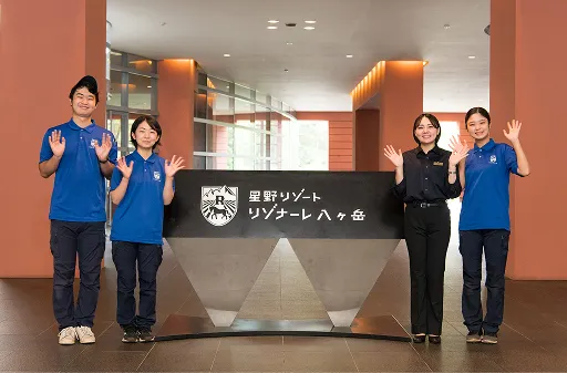 ロビー看板の隣でポーズをとる学生たち