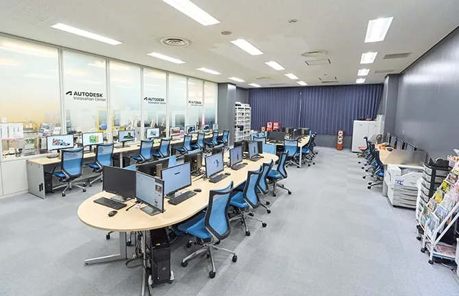 青とグレーの落ち着いた配色の室内にPCが余裕をもって並んでいる様子