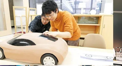 一抱えもあるスポーツカーのような模型を製作している楽しそうな生徒達