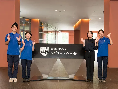 ロビー看板の隣でポーズをとる学生たち