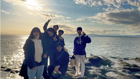 海を背景にポーズをとる学生たち