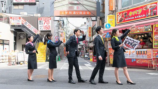 商店街でポーズをとる学生たち