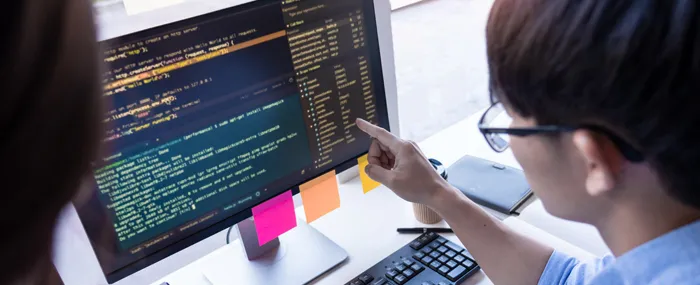 プログラムの検証を指差し確認しながら行っているイメージ画像