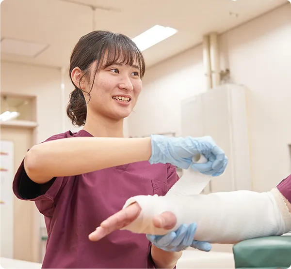 腕に包帯を巻く実習を行う学生