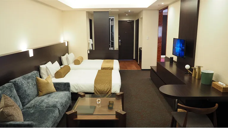 ホテルさながらのソファ、ツインベッド、テレビ、デスクなどが備えられた実習室