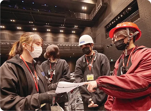 ライブ準備で作業内容を確認する学生達