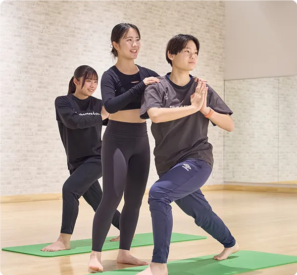 ヨガのフォーム指導・補助技術を学ぶフィットネス実習の様子