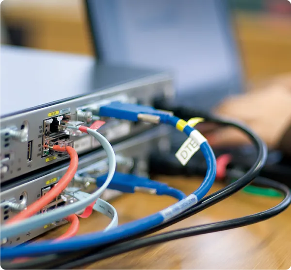 ネットワーク機器につながれた赤青黒のコード