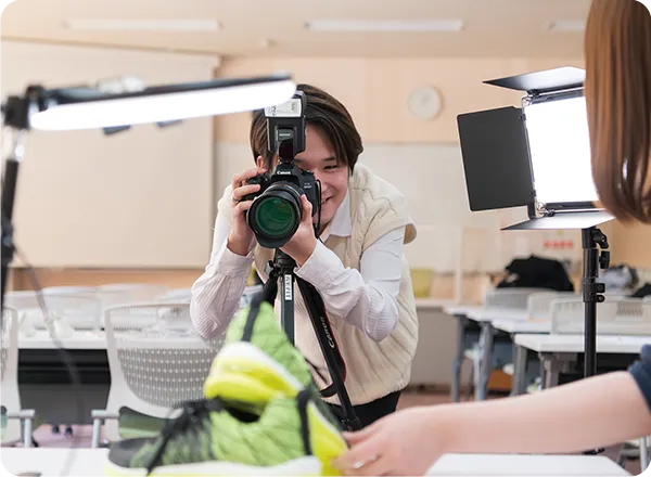 ライティングされた商材をカメラで撮影する学生の様子