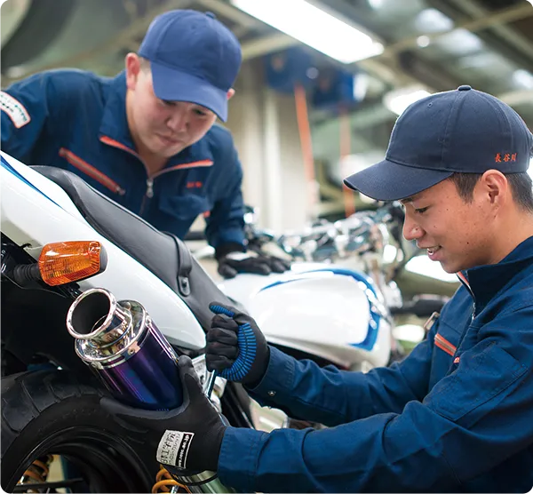 整備実習でマフラーを整備する学生