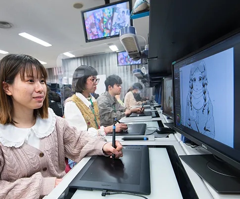 複数の学生がペンタブレットでイラストを描いている様子