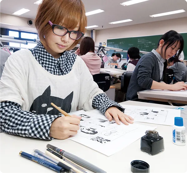 学生が筆ペンでマンガを描いている様子