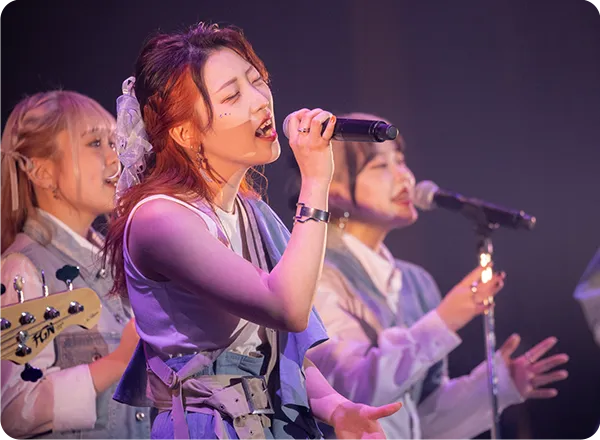複数の学生が舞台で歌や演奏をしている様子