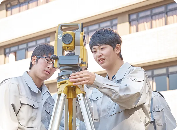 ３名の学生が測量機械を操作している様子