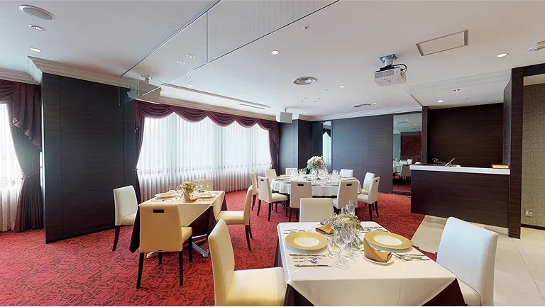 カーペットが敷かれテーブルセッティングが整ったフォーマルな雰囲気の実習室