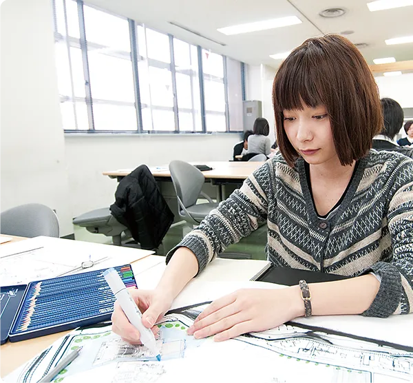 学生が図面にマーカーを入れている様子