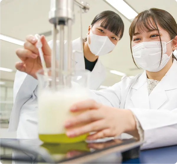 学生がビーカーを持ち実験を行っている様子