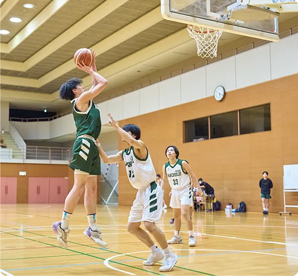 バスケットボールの試合でシュートを放つ選手と守備選手