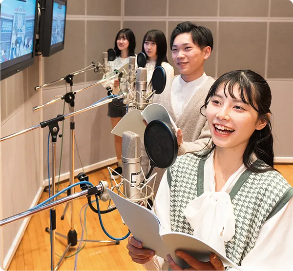 複数の学生がスタジオでアフレコを行っている様子
