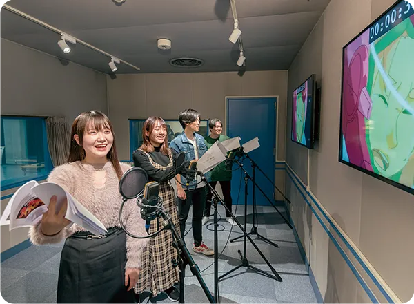 複数の学生がスタジオでアフレコを行っている様子