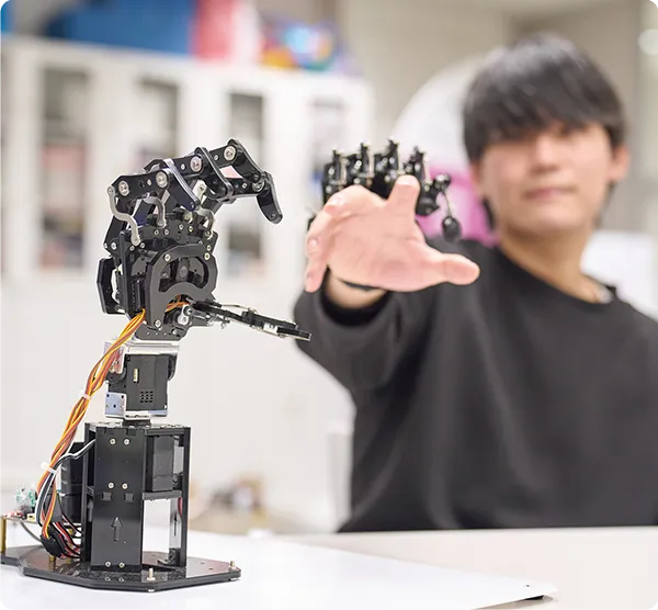 ロボットハンドの動作を確認する学生