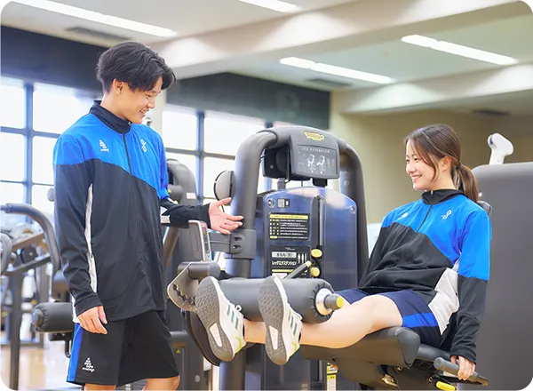 レッグエクステンションマシンでトレーニングする学生