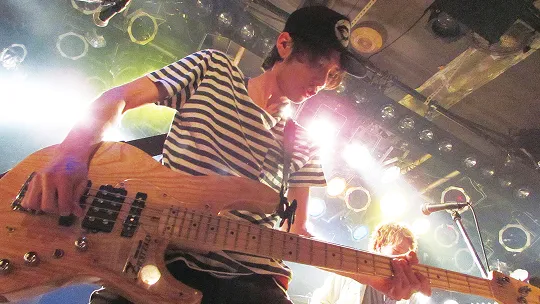 学生が照明に照らされたステージでライブパフォーマンスをする様子