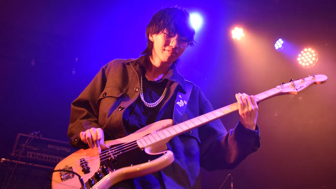 学生が照明に照らされたステージでライブパフォーマンスをする様子