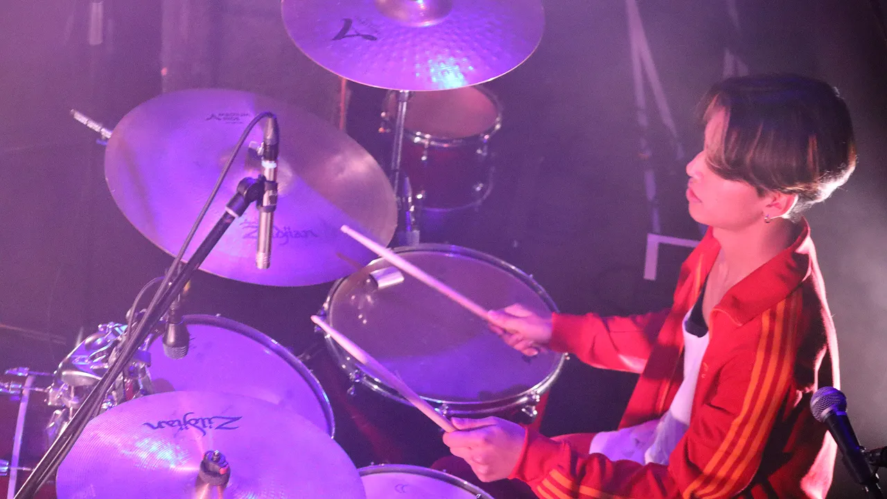 学生が照明に照らされたステージでライブパフォーマンスをする様子