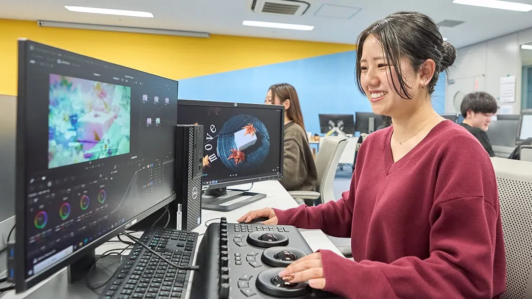 パソコンとポータブルハードウェア・コントロールパネルを使用して映像を編集する生徒