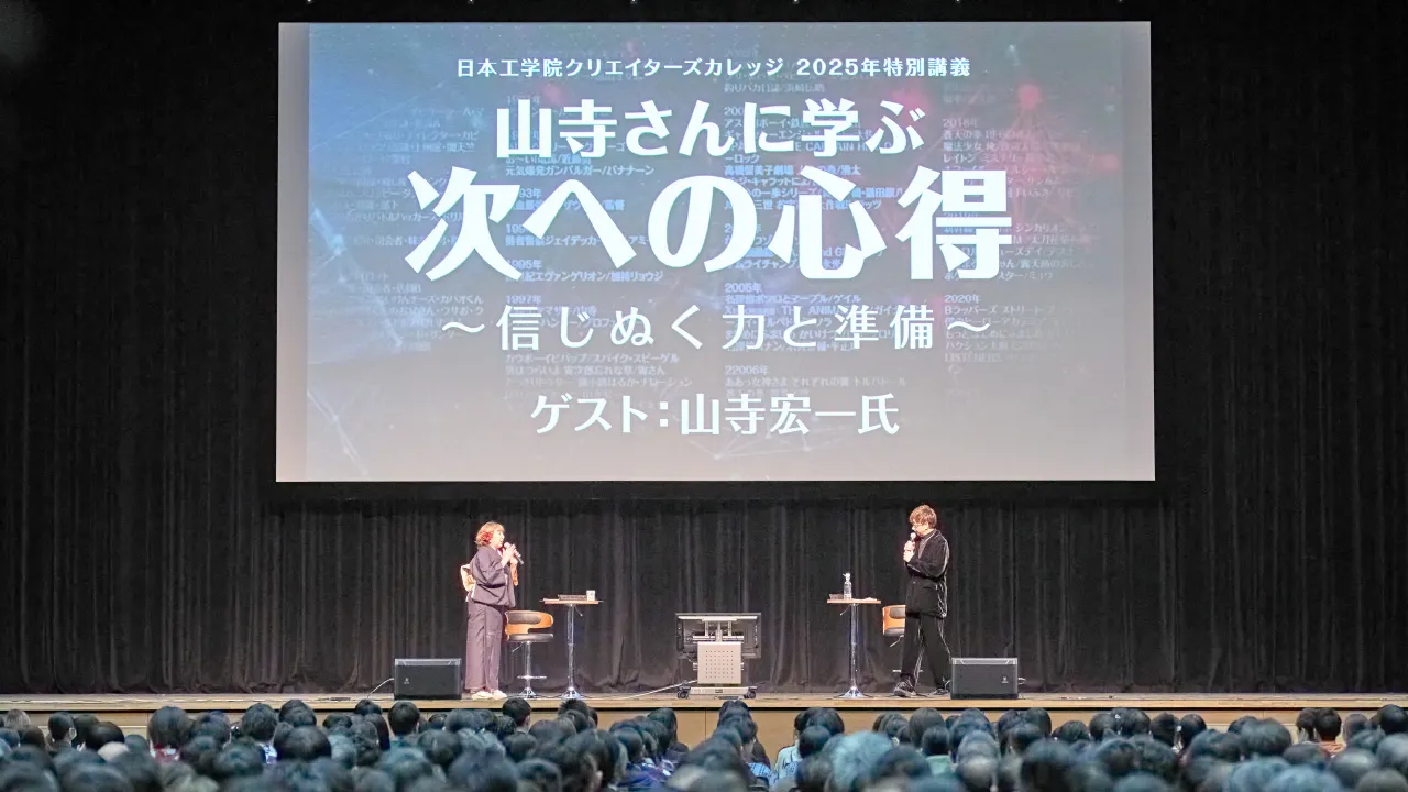 壇上に立ち向かい合ってトークをする富永先生と山寺さん