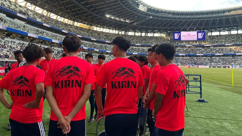 サッカーコースの学生たちがスタジアムのピッチサイドで大会運営に関する説明を受ける様子