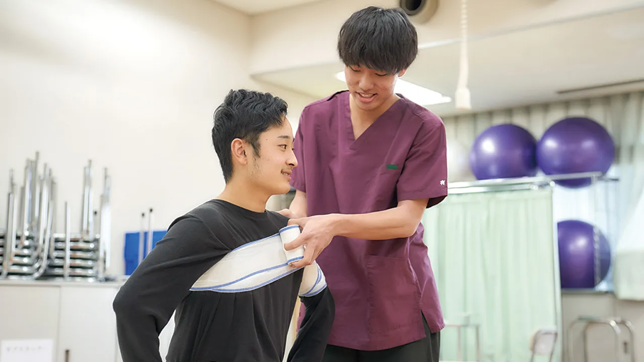包帯で胸部を巻く柔道整復師
