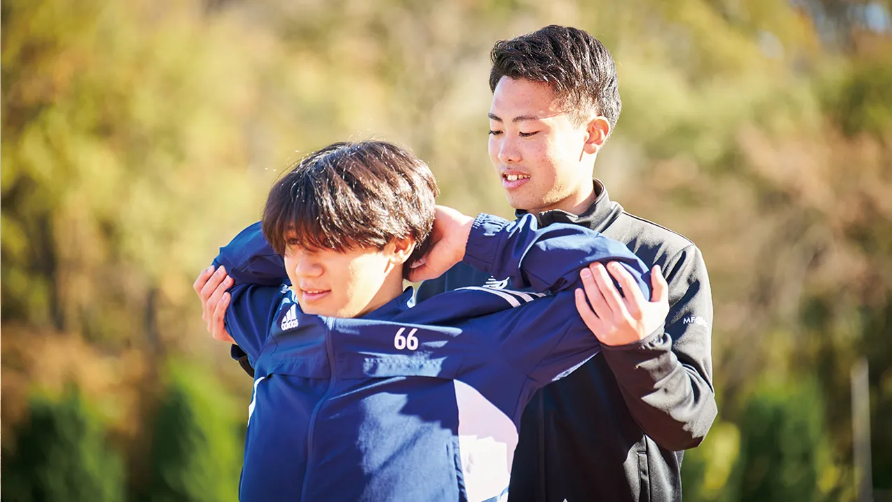 スポーツ選手のストレッチをサポートするトレーナー