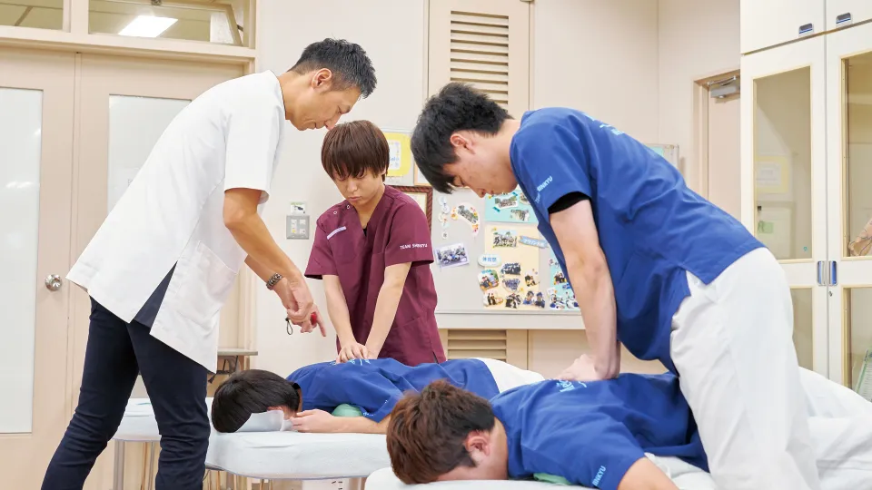 実技実習室で背中の指圧をしている学生